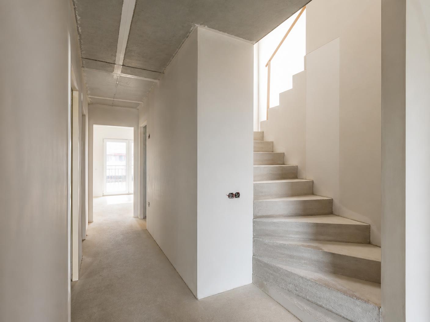 Lege nieuwbouwwoning met vlak afgewerkte wanden en plafond