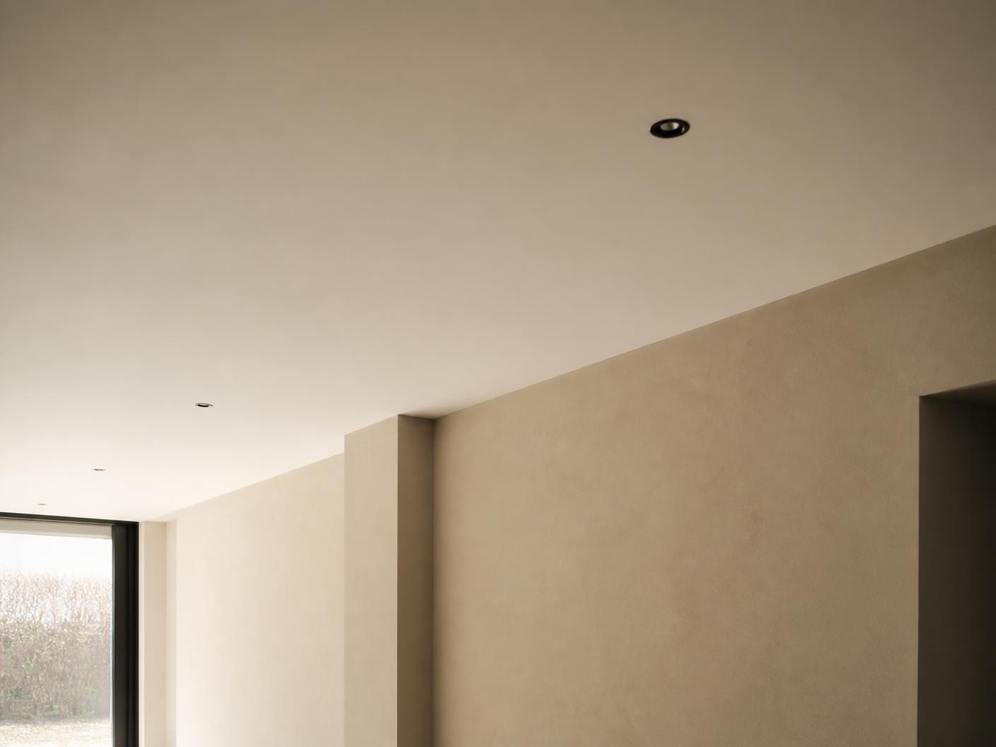 Vlak afgewerkt plafond met inbouwspots in een lege woning